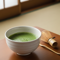 Tè Matcha verde vibrante en bol blanco con batidor de bambú