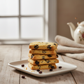 Galletas Garibaldi doradas con pasas apiladas en plato blanco
